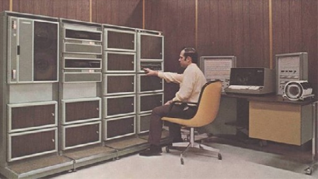 Man working with tape decks on a computer in the 1970's Man working with tape decks on a computer in the 1970's
