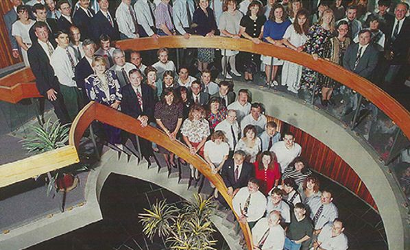 Synergy employees at old headquarters in Rochester on stairs
